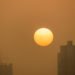 Sun rising behind building in the fog in Chengdu, Sichuan province, China